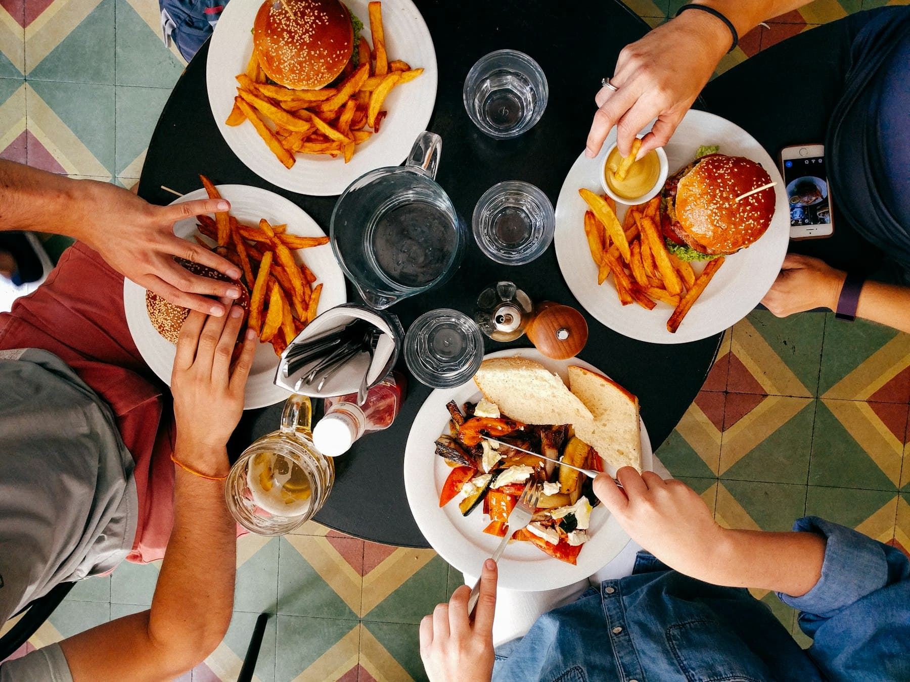 Guests sharing burgers and fries around a table.