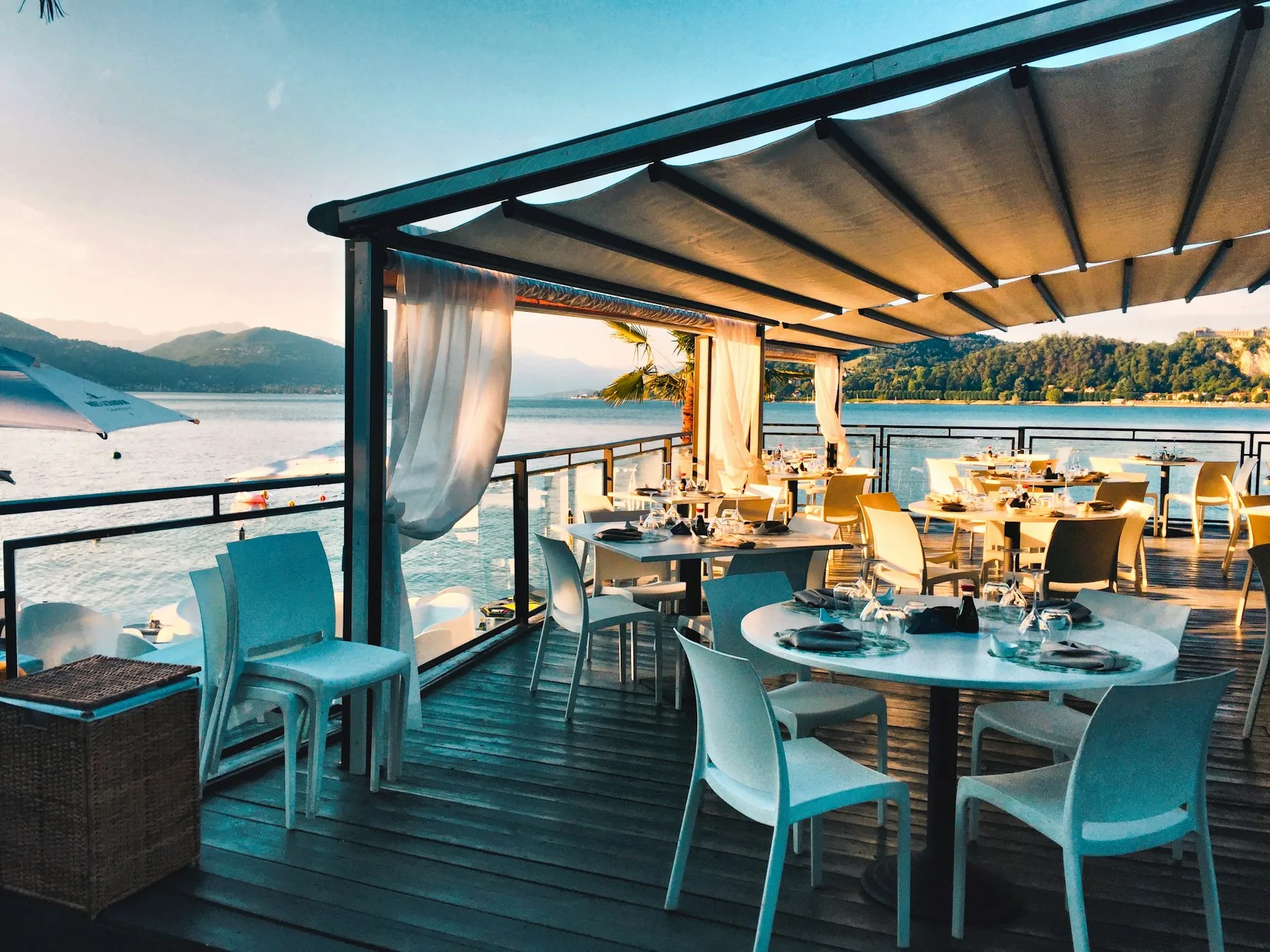 An outdoor restaurant terrace with tables ready for guests.